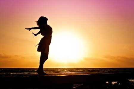 Woman stretching in front of sunset